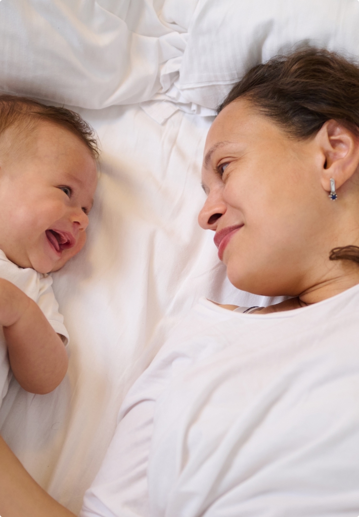 chicago mom on bed looking at baby