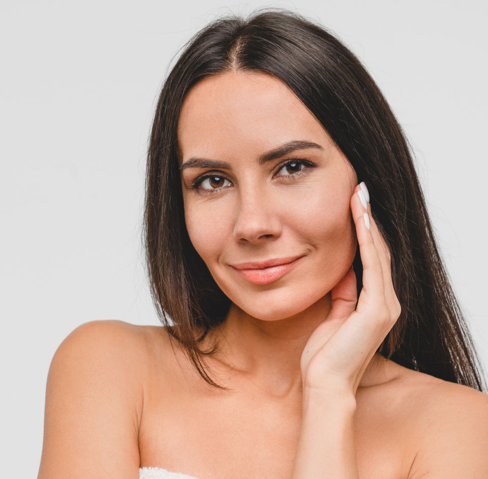 Brunette woman touching her cheek, clear youthful skin